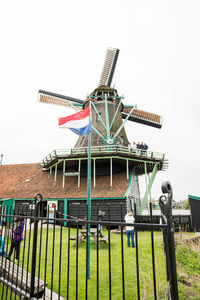 Traditional windmill on field against clear sky