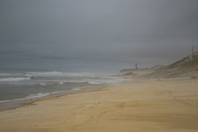 Scenic view of beach and lighthouse against sky