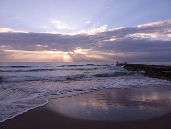 Scenic view of beach against sky during sunset