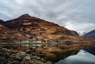 Scenic view of lake by mountains against sky