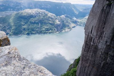 High angle view of rocks by sea against mountains