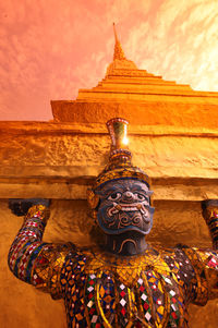 Close-up of sculpture outside temple against sky during sunset