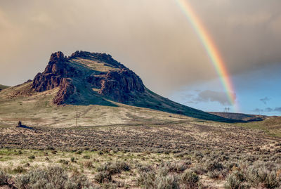 Scenic view of rainbow over mountain against sky