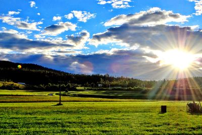 Scenic view of grassy field against cloudy sky