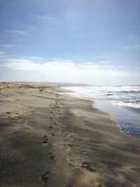 View of calm beach against blue sky