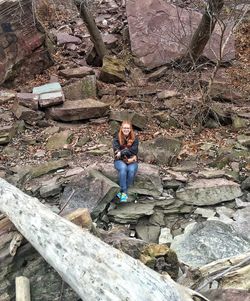 Portrait of young woman standing on rock