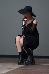 Full length of young woman sitting on floor