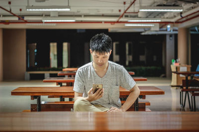 Young woman using mobile phone in cafe