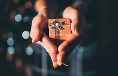 Close-up of hand holding ring in box