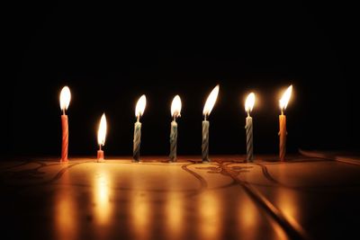 Close-up of burning candles in darkroom