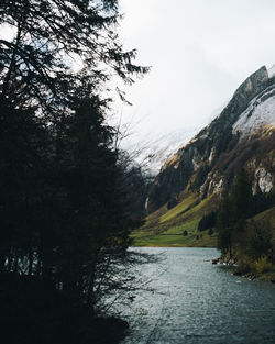 Scenic view of river and mountains against sky