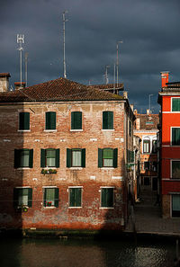 Buildings in city against cloudy sky