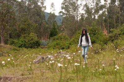 Rear view of woman walking on field