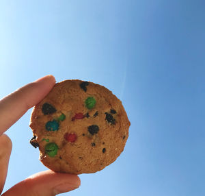 Midsection of person holding ice cream against sky