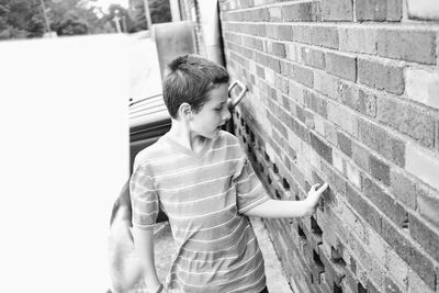 Young woman standing against white wall