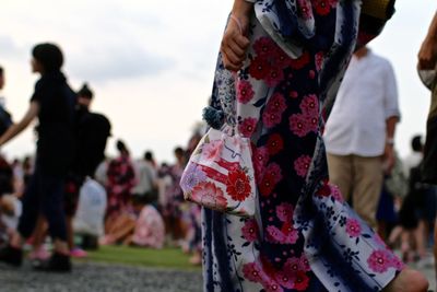Close-up of people standing against the sky