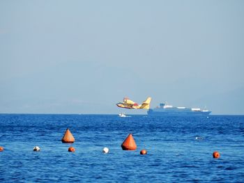 Sailboats in sea against clear sky