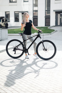 Side view of woman riding bicycle on street