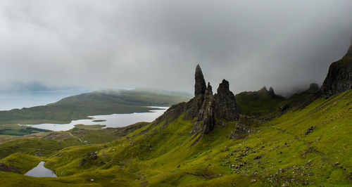 Scenic view of mountain range against cloudy sky