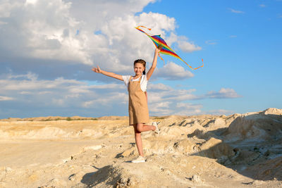 A girl with a kite stands on a mountain and poses. the concept of freedom and fantasy.