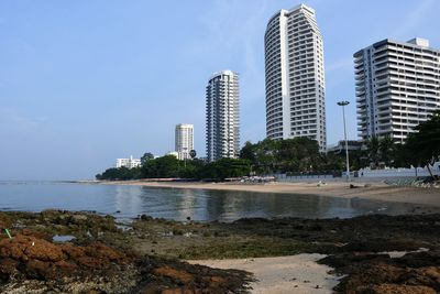 Buildings by sea against sky in city