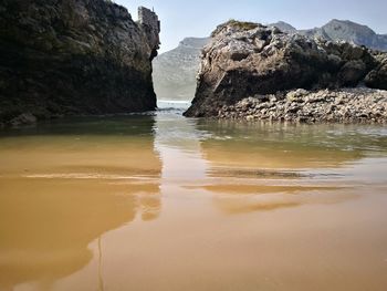 Scenic view of rocks in sea against sky