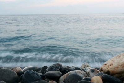 Stones by sea against sky