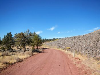 Road amidst landscape against blue sky