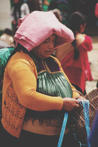 Midsection of woman holding umbrella at market