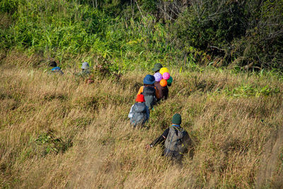 Rear view of people walking on land