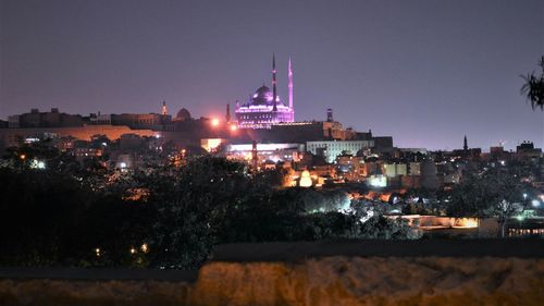 Illuminated city against sky at night