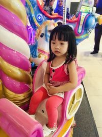 Full length of cute girl sitting with toy