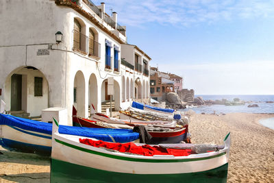 Boats moored on beach against sky