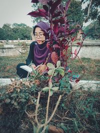 Full length of woman standing by flowering tree