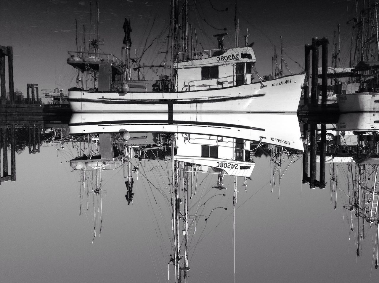 nautical vessel, harbor, moored, water, mast, transportation, mode of transport, commercial dock, reflection, industry, in a row, sailboat, electricity, boat, sky, built structure, outdoors, fuel and power generation, pole, day