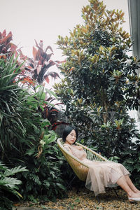 Low section of woman standing amidst plants