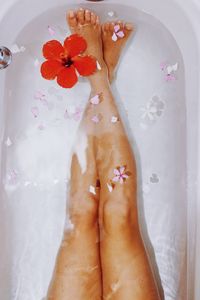 Low section of woman with legs in bathtub