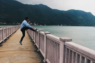 Man standing on pier at lake