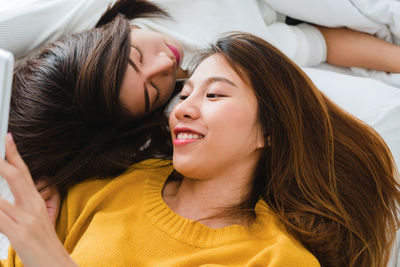 High angle view of women lying on bed at home