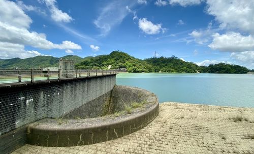 Scenic view of dam by river against sky