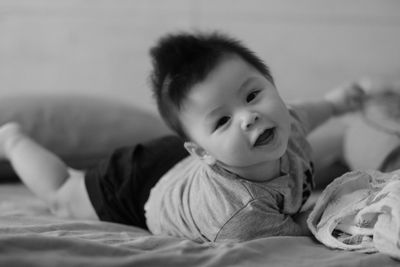 Portrait of cute baby lying on bed at home