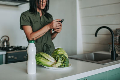 Midsection of woman having food at home