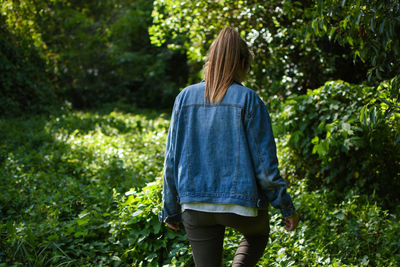 Rear view of woman standing amidst trees