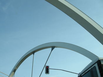 Cropped image of bus on arch bridge by road signal against clear sky
