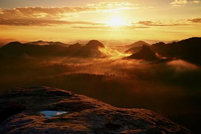 View into long deep valley full of heavy colorful mist. autumn landscape within daybreak after rain