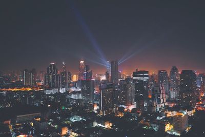 Illuminated cityscape against sky at night