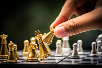 Cropped image of hand playing chess