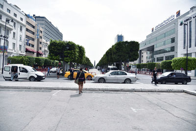 People on city street against sky