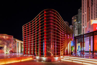 Light trails on building against sky at night