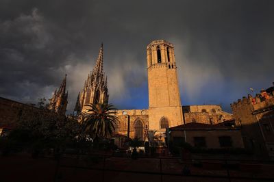 Low angle view of barcelona cathedral against cloudy sky